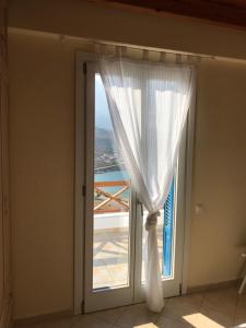 a window with a white curtain in a room at Monolithos Villas in Kipri