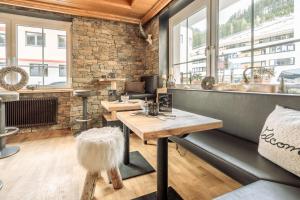 a room with wooden tables and a brick wall at Fortuna Apart Hotel B&B in Ischgl