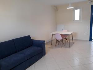 a living room with a blue couch and a table at Monolithos Villas in Kipri