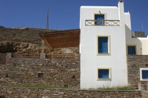 a white building on top of a stone wall at Monolithos Villas in Kipri