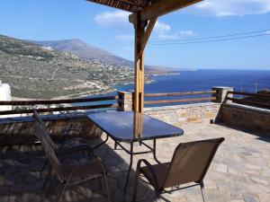 a table and chairs on a patio overlooking the ocean at Monolithos Villas in Kipri