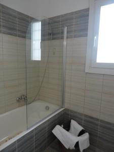 a bathroom with a bath tub and a shower at Monolithos Villas in Kipri