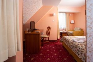 a hotel room with a bed and a desk with a computer at Contessa Hotel in Shumen