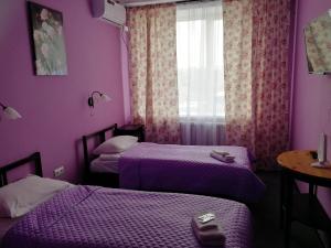 a purple room with two beds and a window at Sleep House Рязань in Ryazan