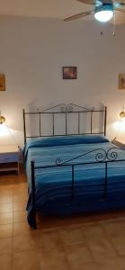 a bedroom with a bed with blue sheets and two lights at CASA MARINA in Lampedusa
