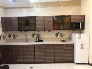 a kitchen with a sink and a refrigerator at دانة الشرق للشقق المخدومة in Al Khobar