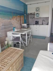 een keuken met een tafel en een keuken met het strand bij Studio Blue Cocoon Westende in Middelkerke