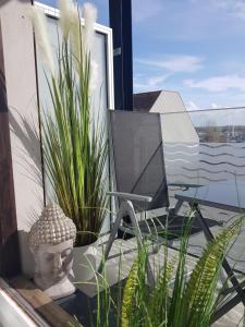 a room with a chair and plants on a balcony at Studio Blue Cocoon Westende in Middelkerke