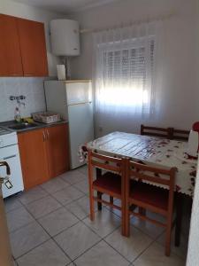 een keuken met een tafel en een witte koelkast bij Danijela in Nin
