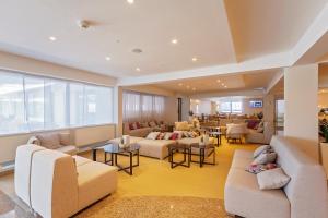 a waiting room with couches and chairs and tables at Hotel Zorna Plava Laguna in Poreč