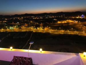 a view of a city at night with lights at Al Tal Serviced Apartments in Baljurashi
