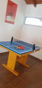 una mesa de ping pong con una paleta de ping pong en Mi lugar Serrano 3 en Valle Hermoso