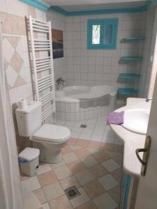 a bathroom with a toilet and a sink and a tub at Villa Kantouni by the sea in Kalymnos +27 photos