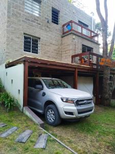 una camioneta estacionada en un garaje al lado de una casa en Gorriones Libres en Villa Gesell