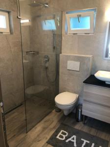 a bathroom with a shower and a toilet and a sink at Mókus Apartmanház in Balatonszárszó +22 photos