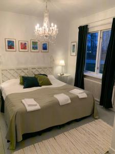 1 dormitorio con 1 cama grande y toallas. en Furulidens Hotell, en Vittsjö