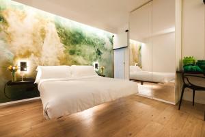 a bedroom with a white bed and a painting on the wall at Miceli Exclusive Suite in Palermo