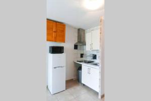 une cuisine avec des armoires blanches et un réfrigérateur blanc dans l'établissement F2 entier CANET VUE MER // BALCON + PARKING, à Canet