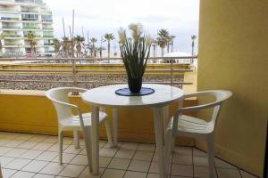 une table blanche avec deux chaises et une plante sur elle dans l'établissement F2 entier CANET VUE MER // BALCON + PARKING, à Canet 4 autres photos