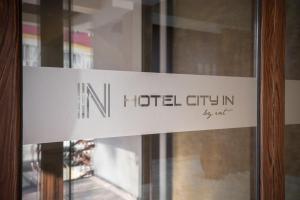 un cartel en una puerta de cristal de un hotel cityitsch en Hotel City IN, en Kočani