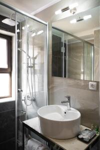 La salle de bains est pourvue d'un lavabo et d'une douche. dans l'établissement Hotel City IN, à Kotchani