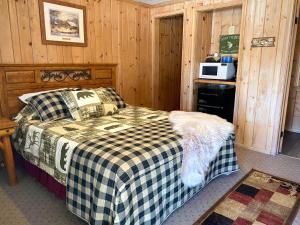 a bedroom with a bed with a checkered blanket at Moosewood Inn in Saint Ignace