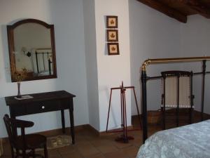 een slaapkamer met een spiegel, een tafel en een bed bij Las Encinas in Yeste