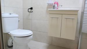 bagno con servizi igienici bianchi e lavandino di Santa maria Zimmer Bahai Gardens a Haifa