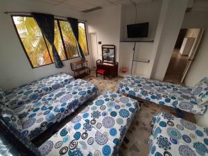 a living room with two beds and a tv at Hotel Sael in Tocaima