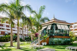 un hotel con palmeras frente a un edificio en Parque Santiago V Official en Playa de las Américas