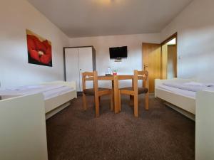 a hotel room with a table and two beds at Hotel Ceteno in Wunstorf