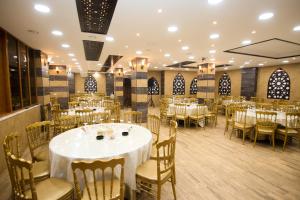 una sala banchetti con tavoli e sedie bianchi di Grape Village Hotel ad Amman
