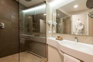 a bathroom with a sink and a shower and a mirror at Holiday Inn Naples by IHG in Naples