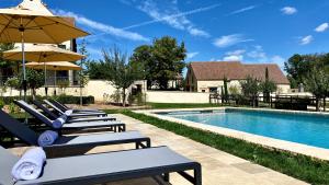 eine Reihe von Liegestühlen mit Sonnenschirmen neben einem Pool in der Unterkunft Domaine de Rymska & Spa - Relais & Châteaux in Saint-Jean-de-Trézy