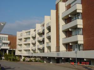 un edificio de apartamentos con balcones en el lateral de una calle en Villa am Meer (Ostsee), en Grömitz