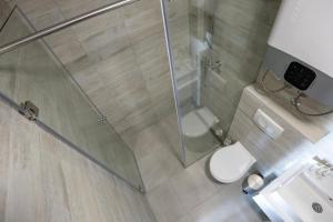 y baño con ducha, aseo y lavamanos. en Belvedere Hills Luxury Apartments and Spa, en Kopaonik