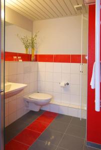 a bathroom with a toilet and a sink at ParkHotel Nieheim in Nieheim