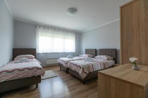 1 dormitorio con 2 camas, mesa y ventana en Apartmani Slavek, en Jastrebarsko
