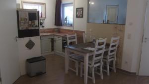 a kitchen with a table and chairs and a refrigerator at Ferienwohnung Apfelbaum in Schonungen