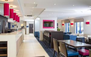 una sala da pranzo con tavolo e sedie di Holiday Inn Express London - Wandsworth, an IHG Hotel a Londra