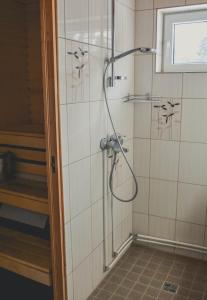 a shower with a shower head in a bathroom at Haanja Guest Apartment with Sauna in Haanja