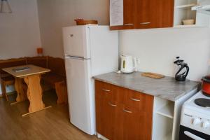 a kitchen with a white refrigerator and a table at Haanja Guest Apartment with Sauna in Haanja