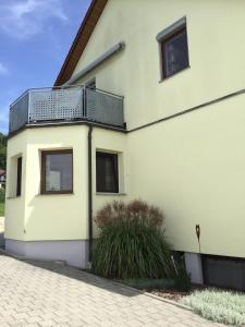 uma casa branca com uma varanda ao lado em Ferienwohnung Ernst em Riedenburg