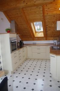 cocina con armarios blancos y techo de madera en Ferienwohnung Ernst en Riedenburg