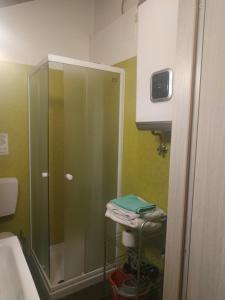 y baño con ducha acristalada y lavamanos. en Mansarda Arel, en Turín