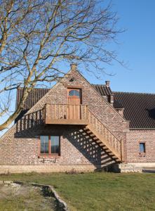 a house with a deck on the side of it at De Heide, cozy apartment with separate entrance in Kampenhout
