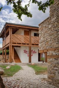 un edificio con una señal que lee sinergia toma en Къщи за гости Сноуфлейк Snowflake Chalet and Snowflake Lodge en Bansko