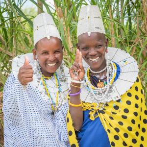 two older women giving the thumbs up sign at Lake Natron Maasai giraffe eco Lodge and camping in Mtowabaga