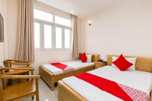 a bedroom with two beds with red and white sheets at Ph&uacute; Ho&agrave;ng Nam Hotel in Ho Chi Minh City