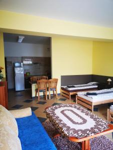 a living room with tables and chairs and a kitchen at Apartamenty Sokółka in Sokółka